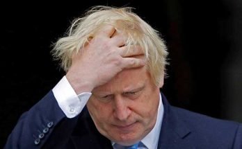 Boris Johnson holding his head in his hand